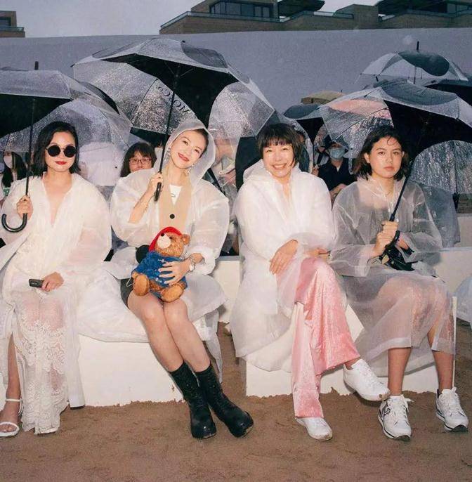 穿透明|章子怡雨中撑伞看秀,穿透明雨衣踩短靴,坐C位抱小熊哪像俩娃妈