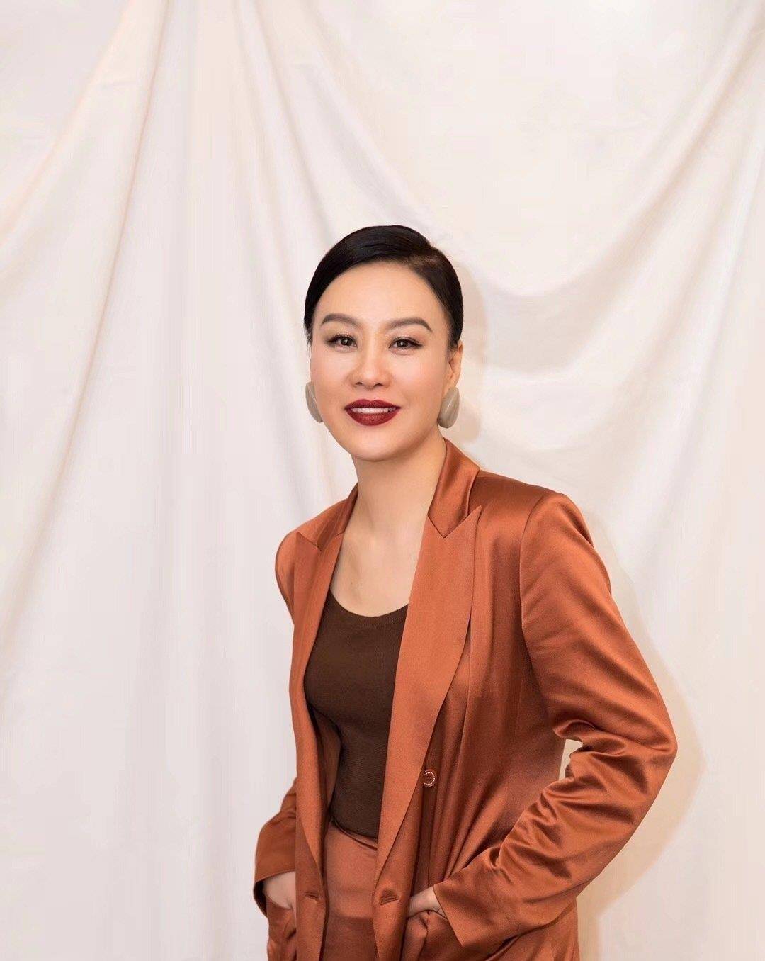 显得|又被邬君梅的气质感惊艳了，缎面西装配低丸子头，简约又大气