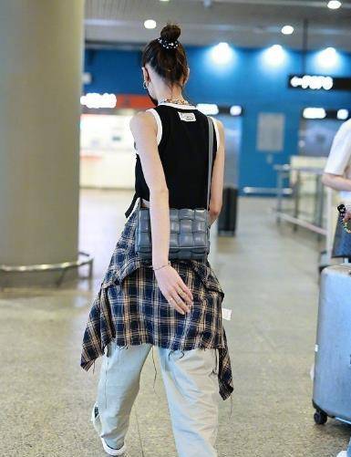 黑色 “大表姐”刘雯走机场不怕冷,黑色肚兜露肚脐眼,胳膊细得像小孩