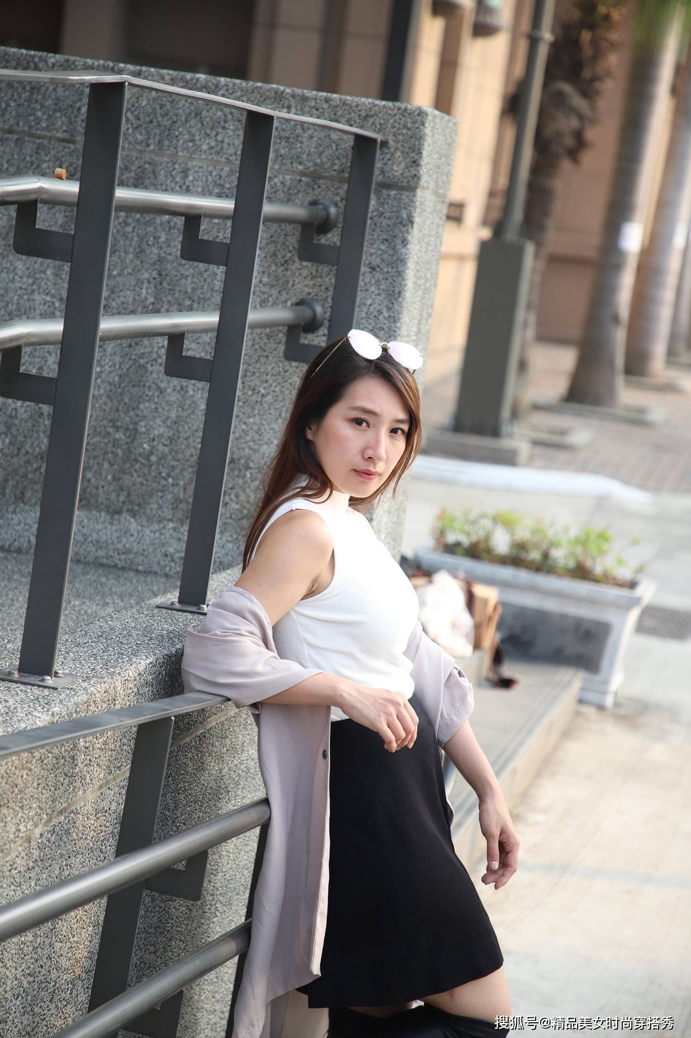 黑色 白色的无袖背心，下搭黑色的半身裙与黑色过膝长靴帅气又时尚