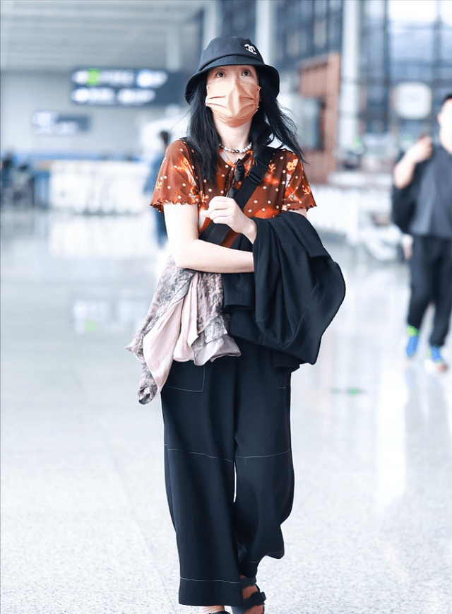 个性 周迅走机场挺“张扬”，穿棕色星空小半袖，脚上穿的粉袜子更抢镜