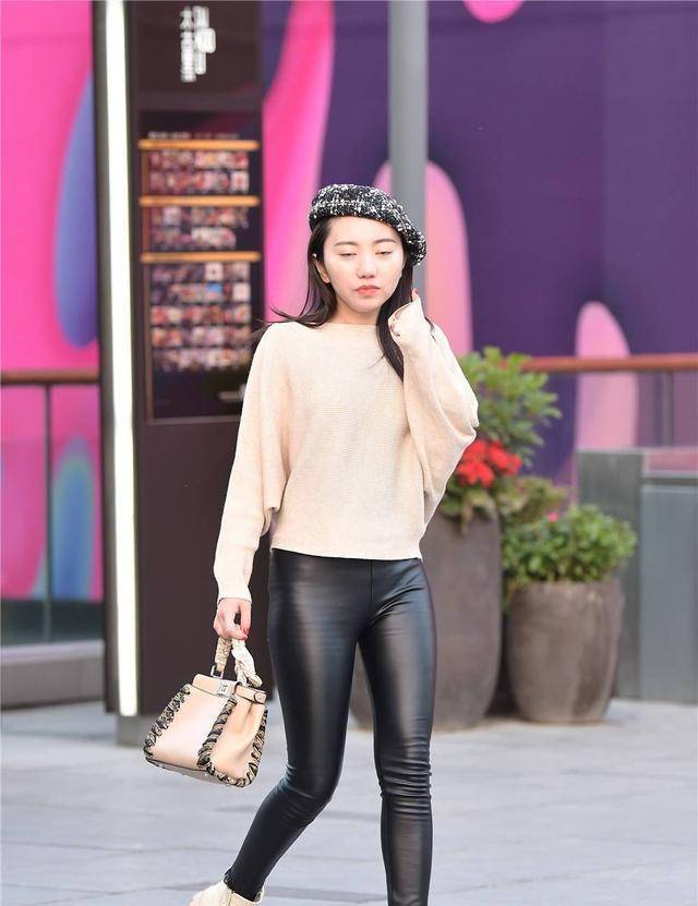 身材 黑色紧身皮裤搭配米色的马丁短靴，有点不一样的味道，衬托身材