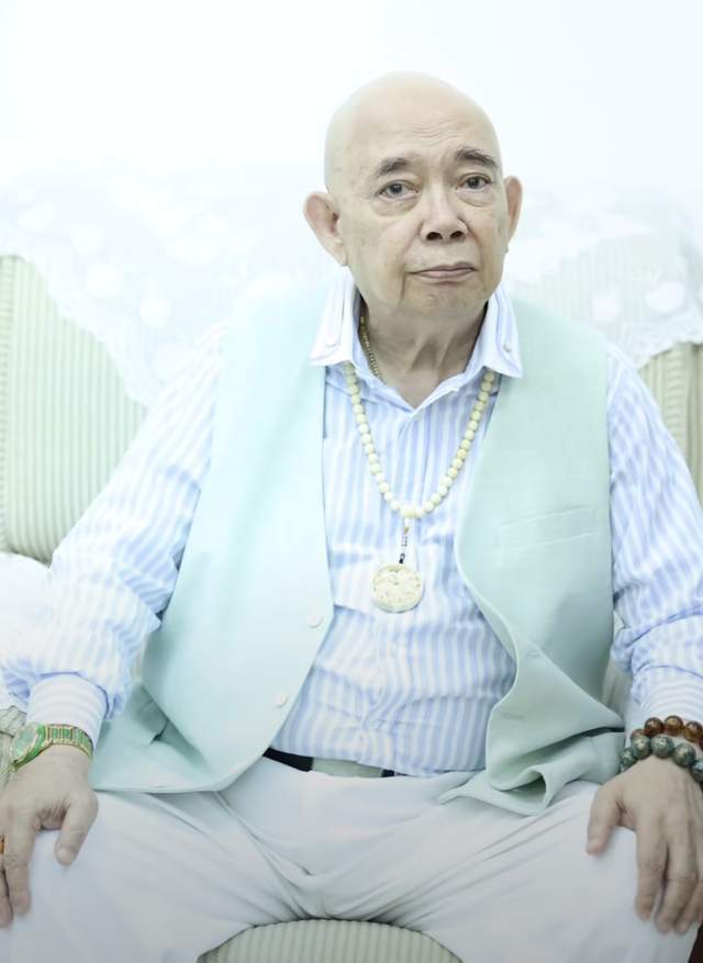 原创港星黄一飞定居内地出席活动牵手年轻女子挂满首饰步履蹒跚