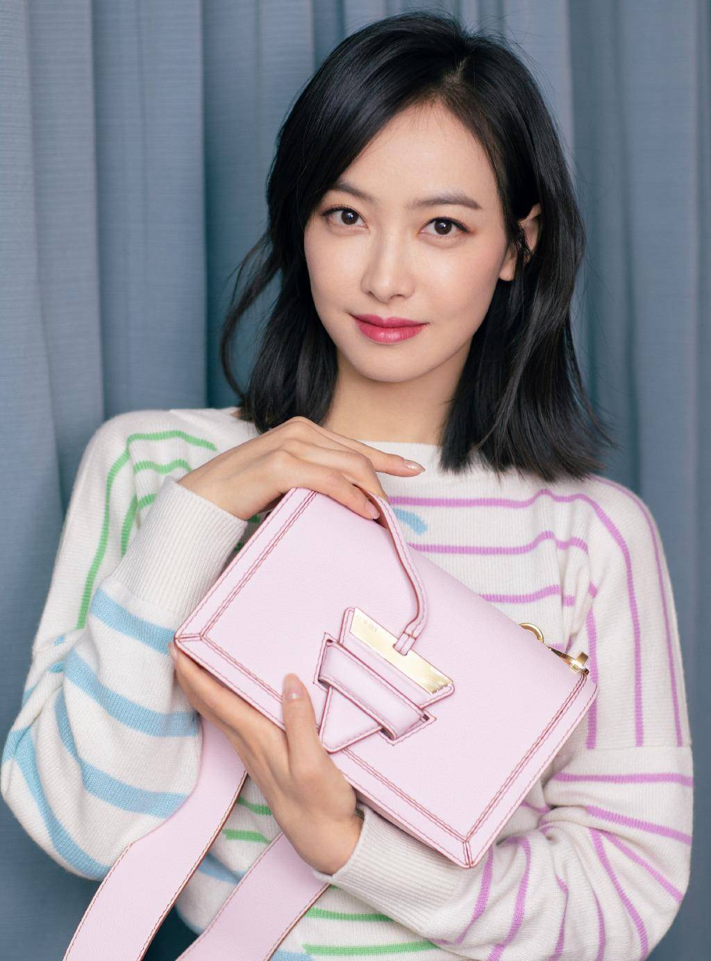 的针织衫,圆领的领口设计突出了细长的颈部比例,搭配及肩的短发发型