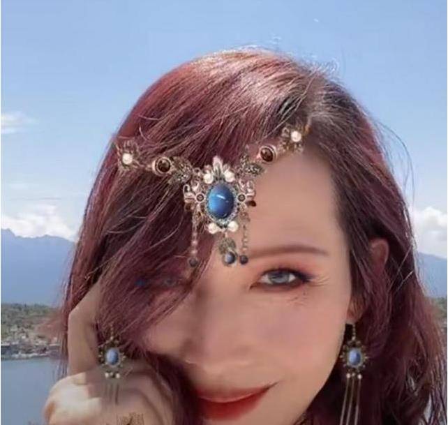 视頻中,蔡少芬穿着一件紧身的乳白色吊带背心,存着一头珊瑚色的波浪