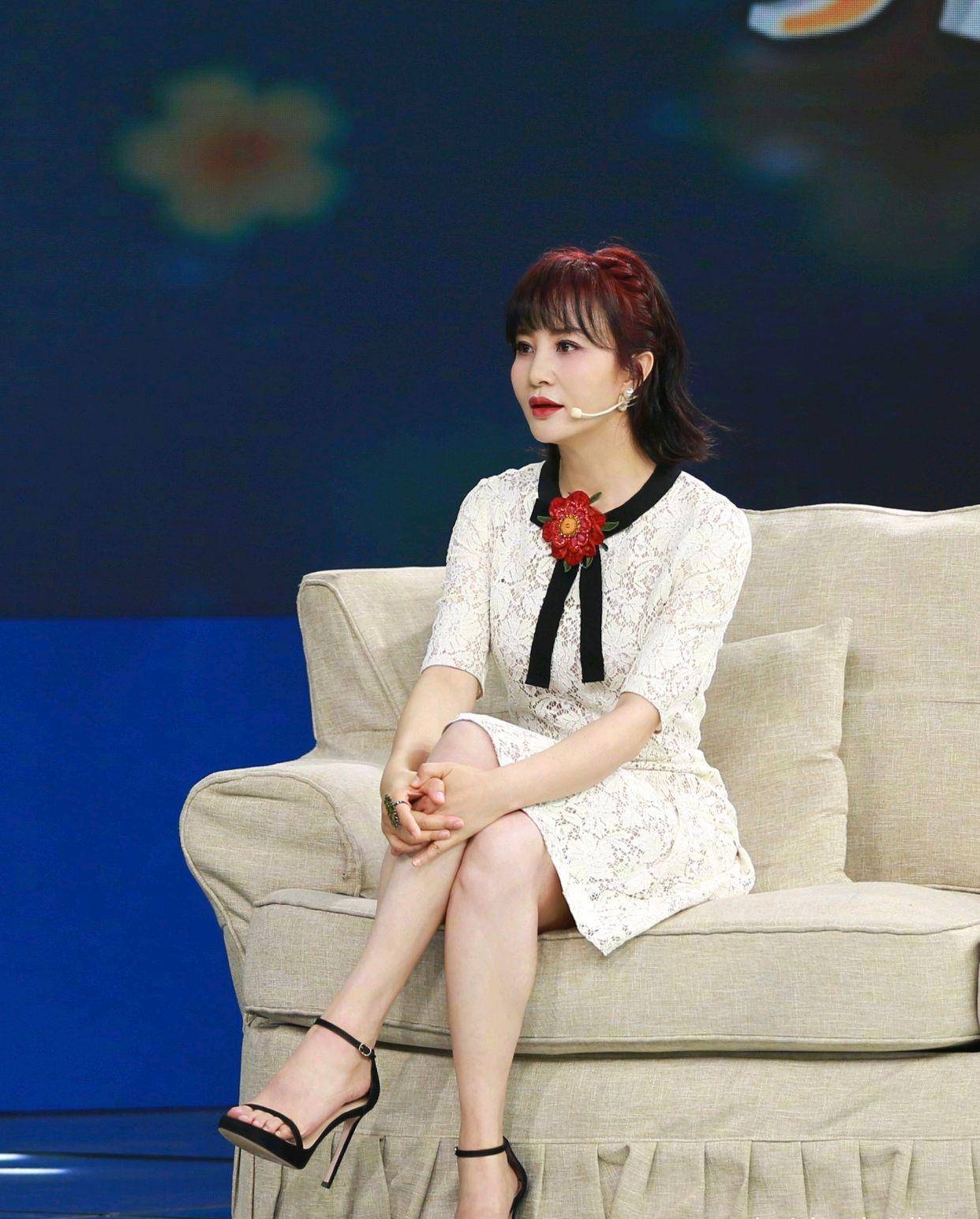 51岁的陶红时尚犹存,身穿白色连衣裙配高跟凉鞋,居然