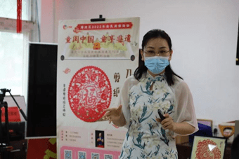 传承人倪巧凤老师在孩子们热烈的掌声中登场,一边展示着作品一边讲述