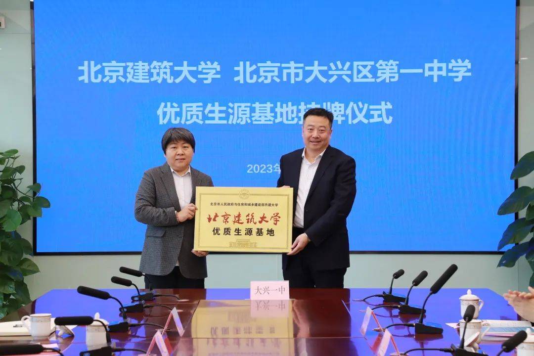北京建筑大学校长助理蔡国庆,大兴一中校长助理张丽代表学校互赠礼物.