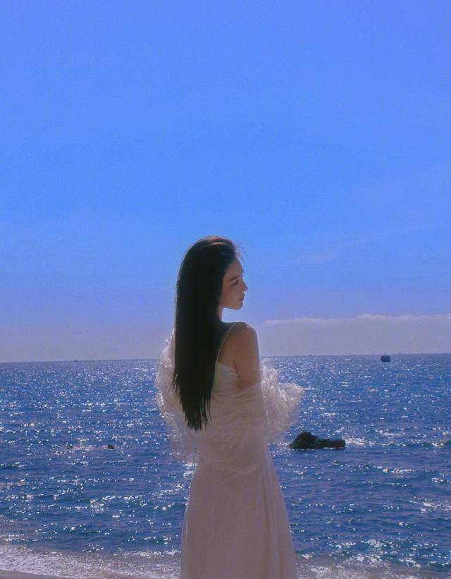 女星张馨予分享海边写真,身穿白色吊带长裙,长发美颜融入海天里_照片