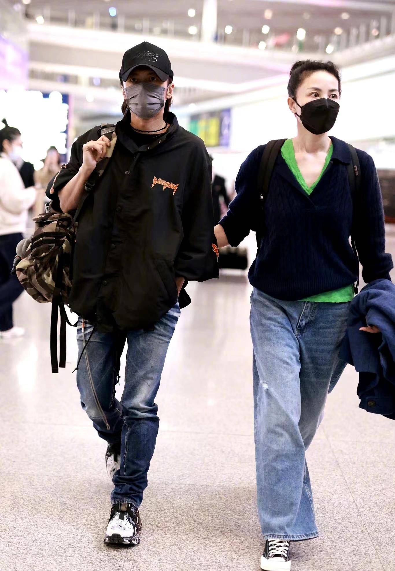 王菲谢霆锋挽手走机场,休闲装扮简约接地气,扎丸子头好清爽!