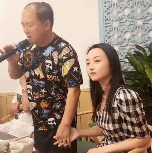 53岁唐鉴军参加饭局唱歌,和身旁女孩十指相扣,二人至少差20岁_女儿