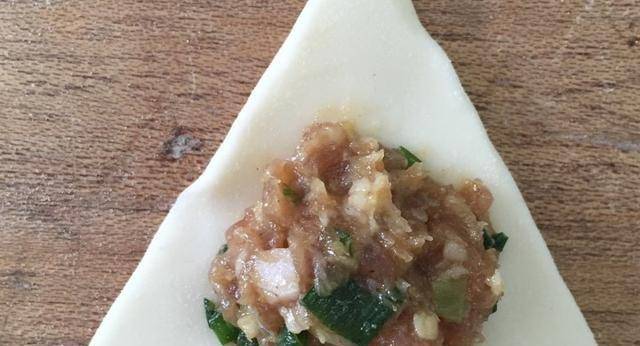 折叠等边三角形在饺子皮的一侧撒粉温水面属于花式蒸饺.