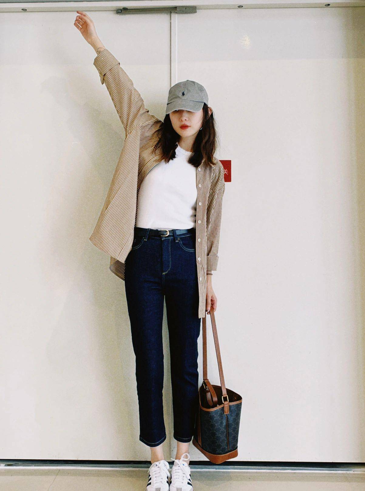 二,牛仔裤搭配黑色风衣外套搭配灰色直筒裤和白色德训鞋,利落的风衣