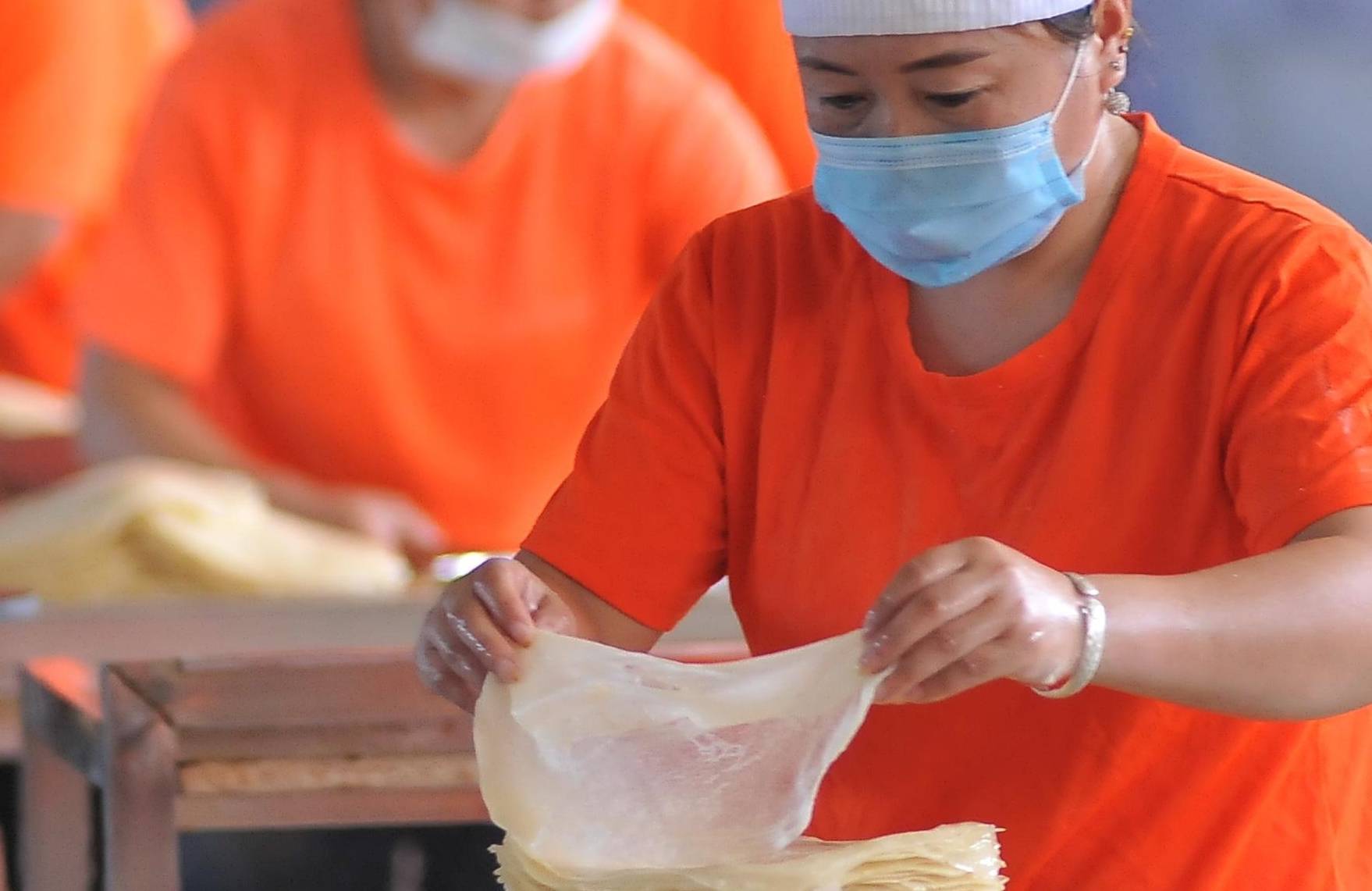 何旭加工厂里的工人正在制作筋饼在何旭即将要放弃的时候,一次和微商