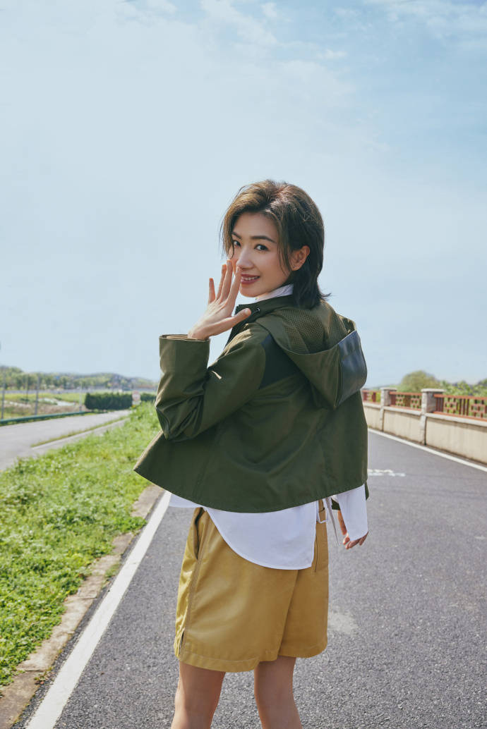 万茜也留着一头短发,回眸的瞬间也露出了甜甜的笑容,用手捂着自己的小