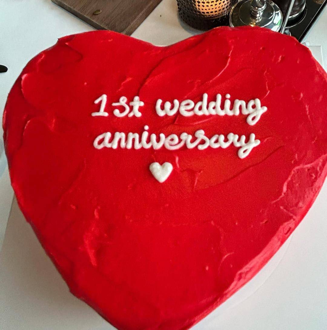 香槟和鲜花相伴,蛋糕上还用英文写着"结婚一周年"的字样