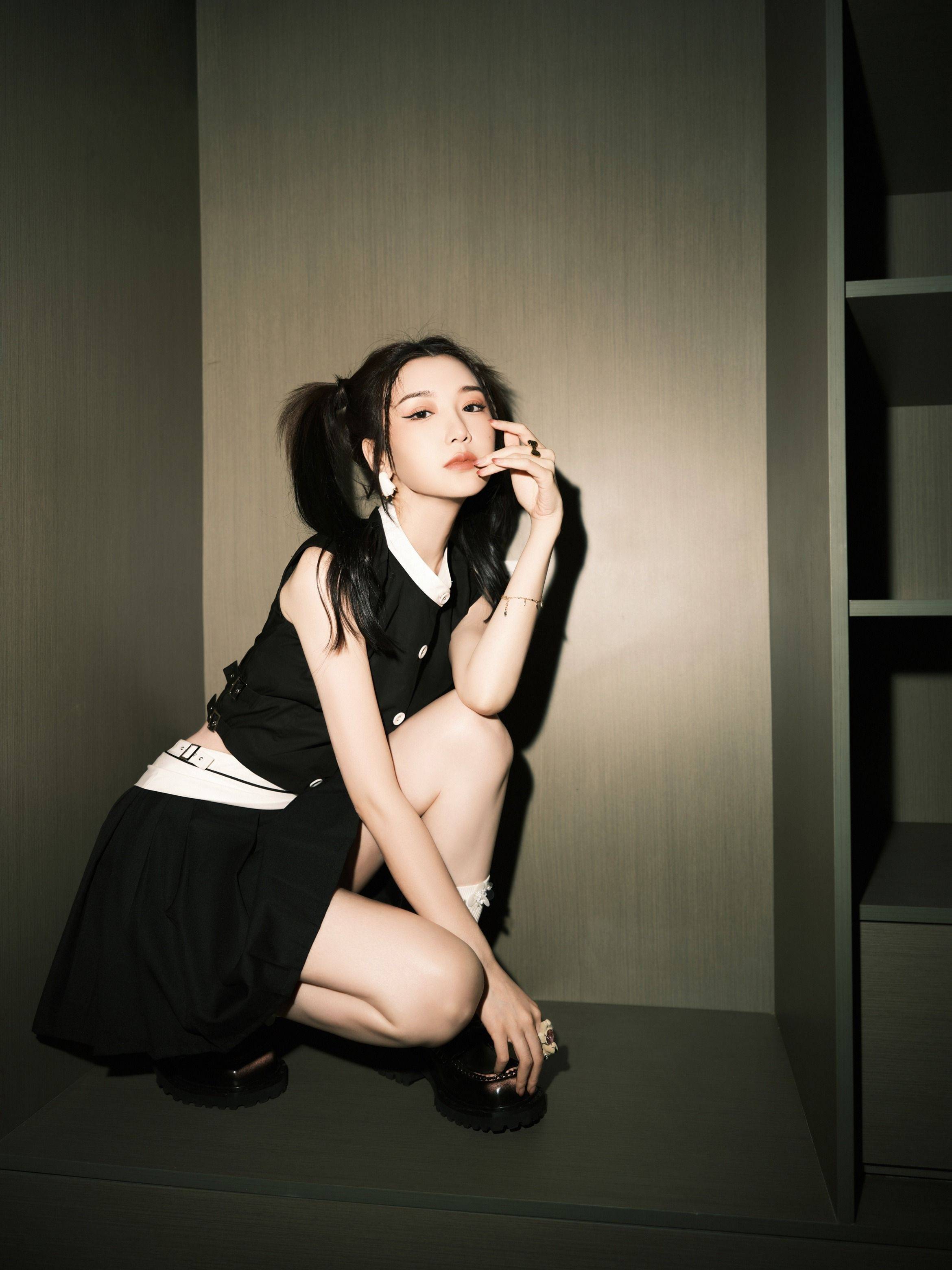 毛晓彤身穿黑色吊带短裙,搭配黑色高跟鞋,大秀美腿,一双白皙修长的