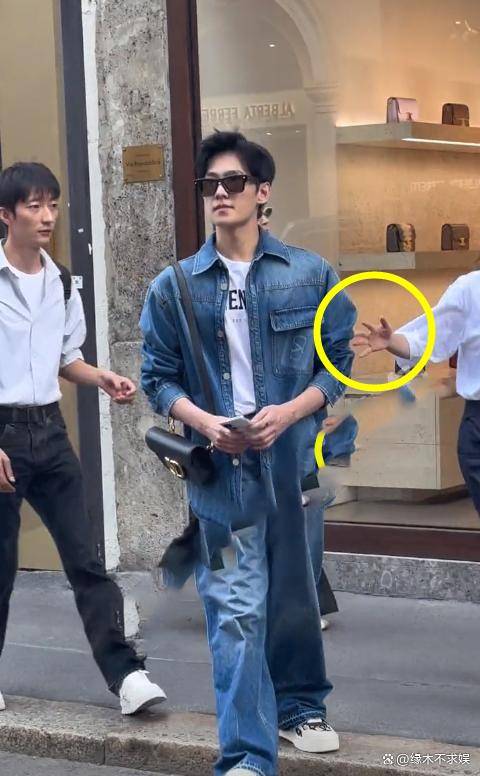 杨洋前后都簇拥着工作人员,左边穿着白衬衫的是杨洋的贴身助理;右边