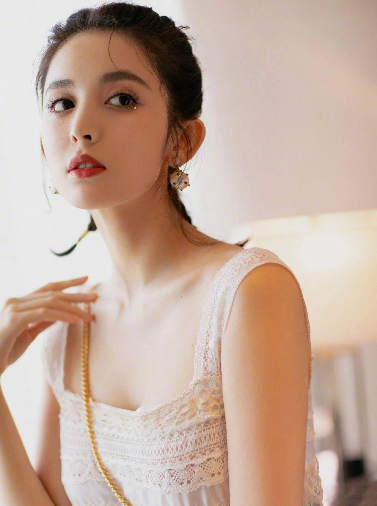 "图中,古力娜扎留着一贯的短发,背上扎着俏皮又甜美的麻花辫,身穿无袖