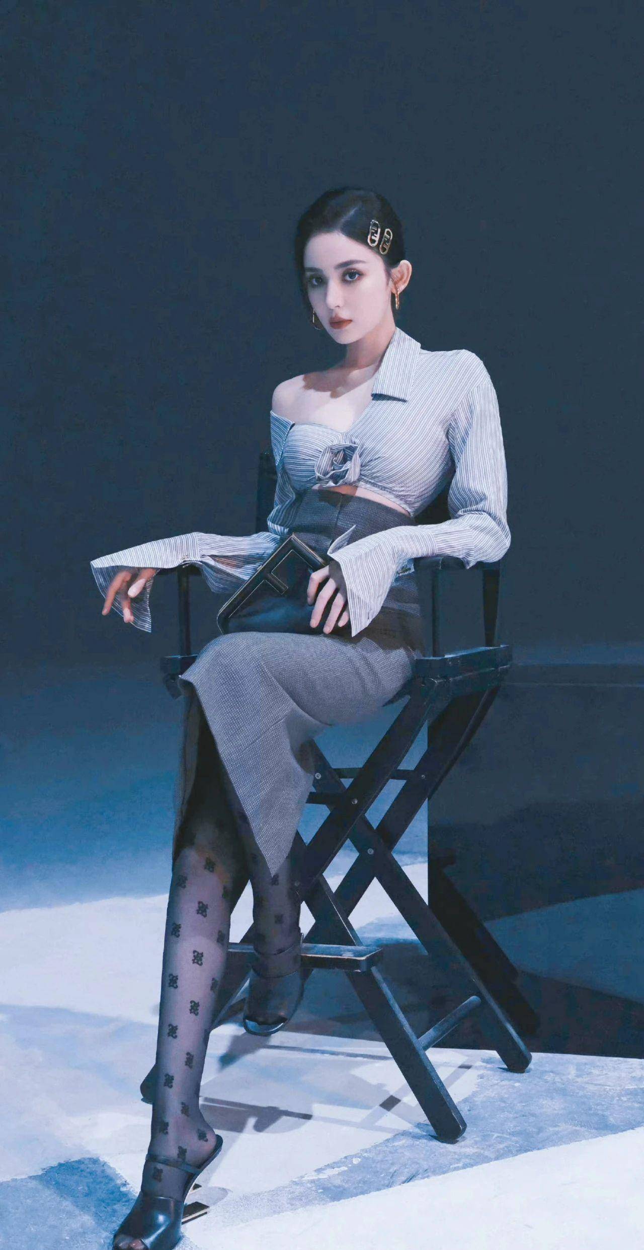 时尚写真拍摄中,古力娜扎第二套衣服选择了条纹衬衫,身穿高腰修身露臀