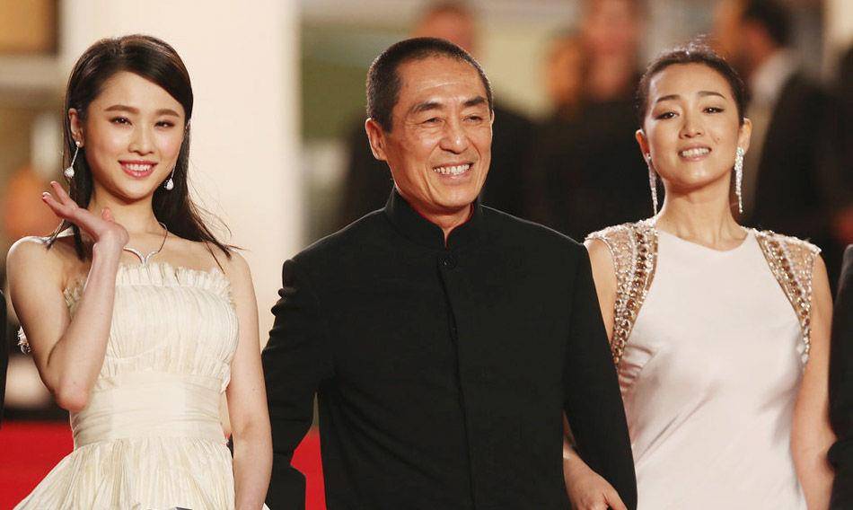 巩俐和陈道明携手走红毯,穿着优雅的白色连衣裙,张艺谋束手无措地爆笑