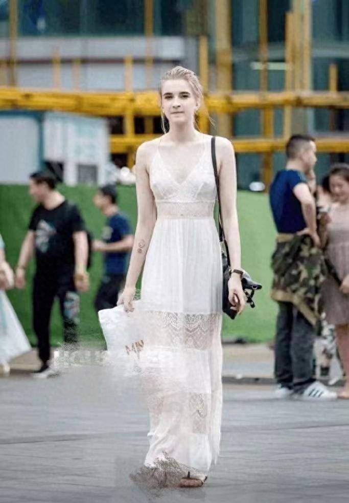 这位美女的衣服设计真是大胆。她穿着薄纱裙，裙子是镂空的，露出了内心的尺寸