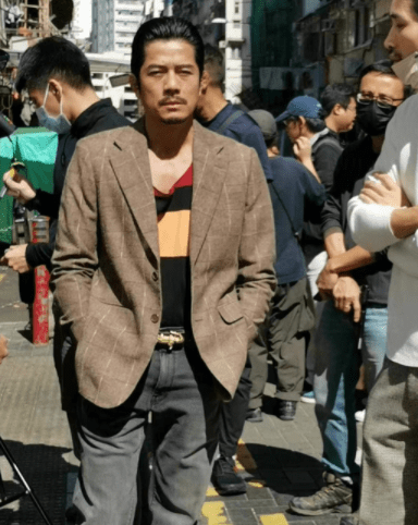 少见地戴上活动假牙扮起了一名龅牙悍匪,只见他梳了一个大背头发型,戴