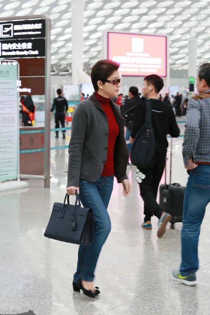 杨澜走机场还带保镖,被拍到不修图成奶奶,头发稀疏沧桑,但穿大衣气质