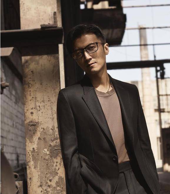 照片里谢霆锋带着眼镜,靠着墙,身型非常的纤长,西装更是趁的他很大气.