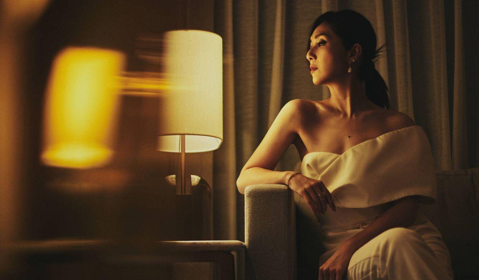 照片中,杨千嬅身穿白色筒装,展现出完美的身材比例和高挑的身材.