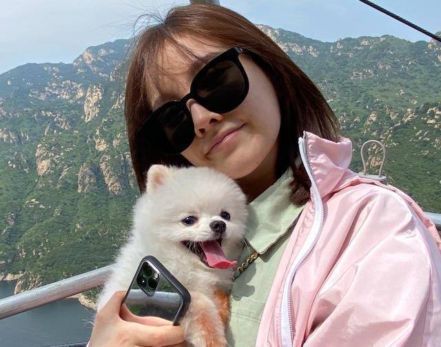 后三张照片都是冯提莫的游客照,戴着墨镜抱着狗狗