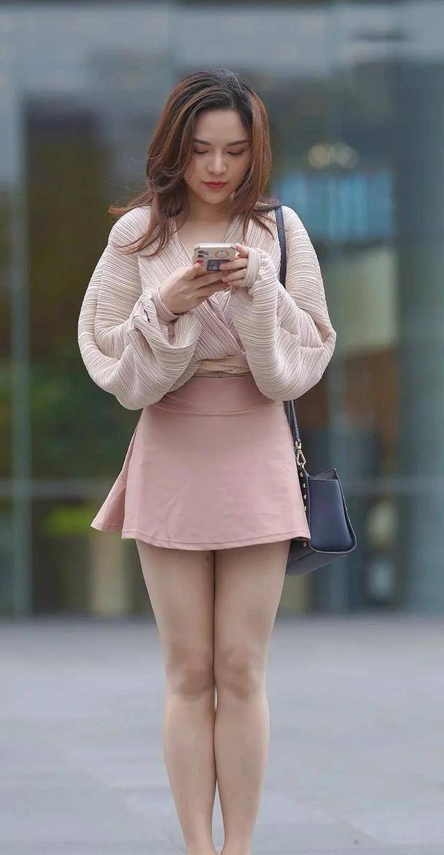 蓬松款亚麻上衣,搭配淡粉色迷你裙,白嫩美腿很醒目