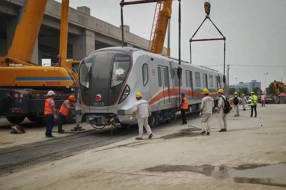 两辆吊车将列车从平板车缓缓吊起