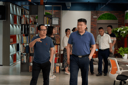 顺风传媒董事长韩顺兴为肖雄伟部长一行介绍公司整体环境在公司参观