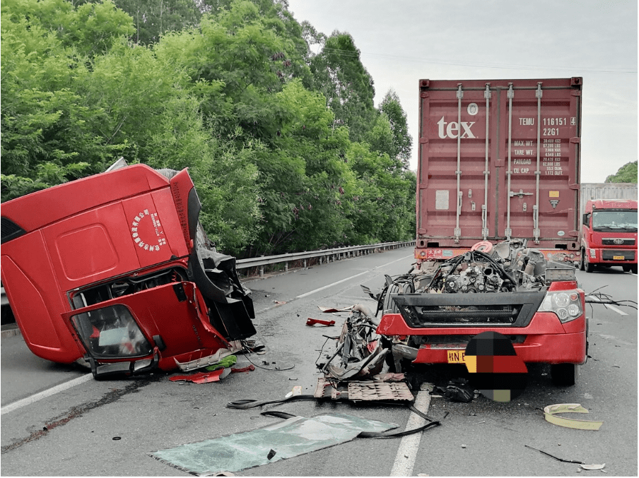 发生一起两货车追尾的交通事故,其中一辆货车车头被撞断脱落在应急