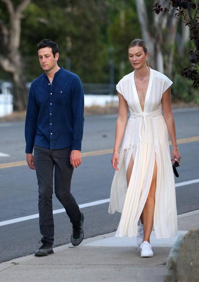 卡莉·克劳斯(karlie kloss)穿着时尚的白色长裙和丈夫在洛杉矶