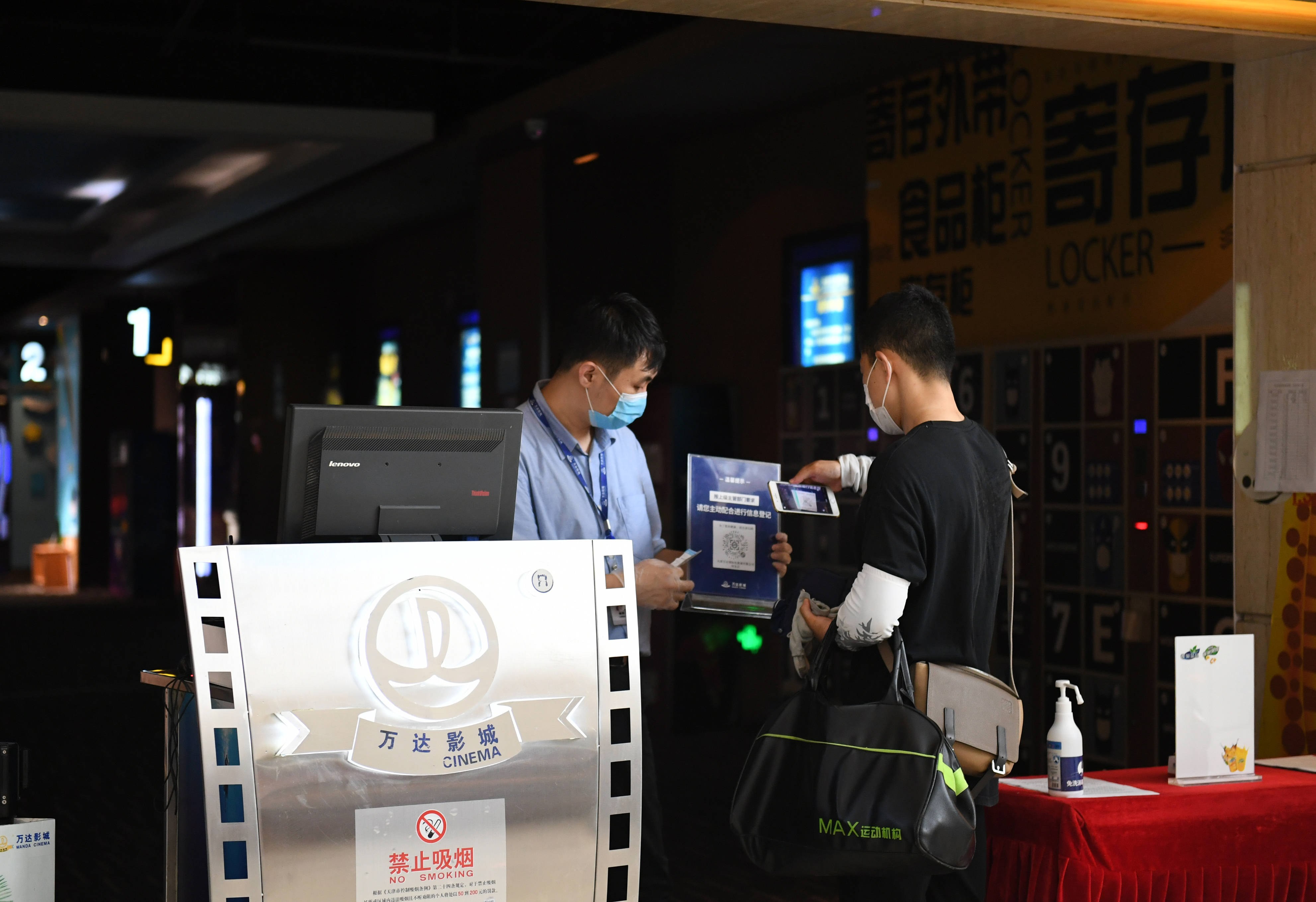 7月20日,观众在天津市一家电影院检票口扫码登记个人信息