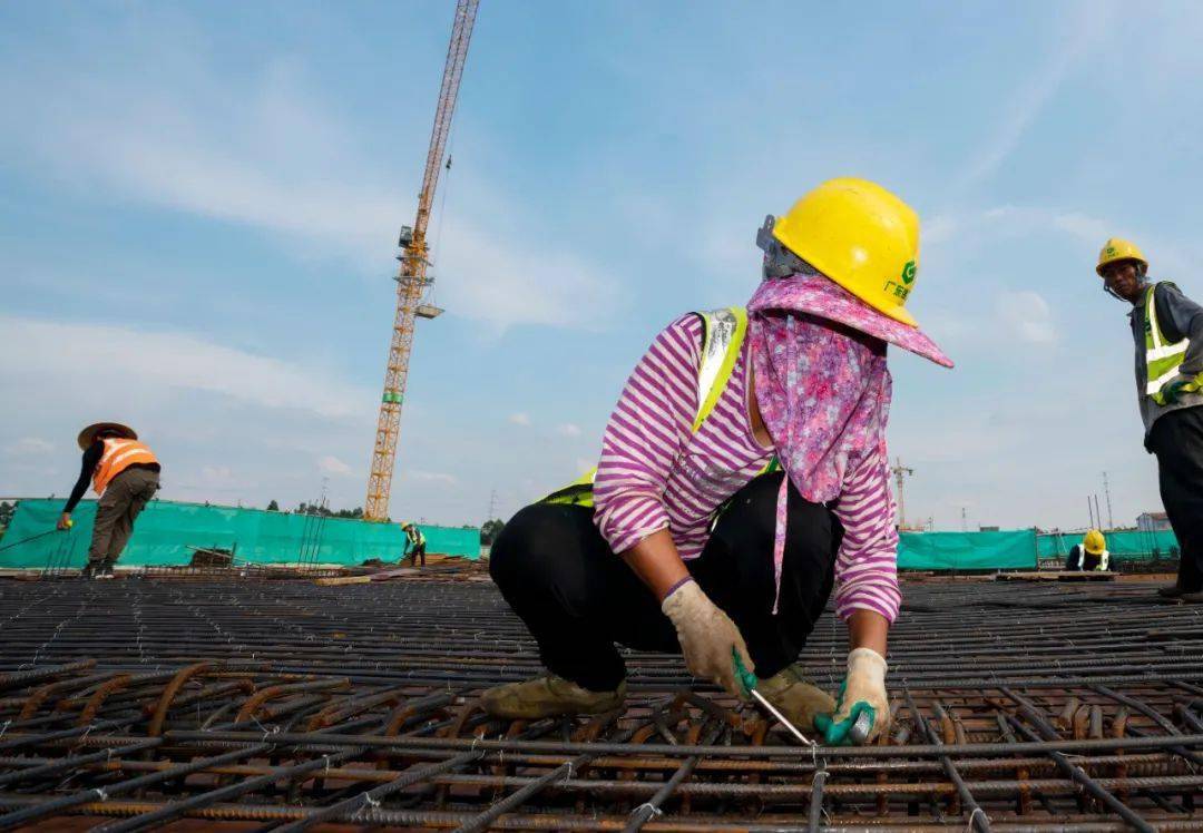 7月27日,工地上一些建筑工人做足防晒措施进行施工作业.