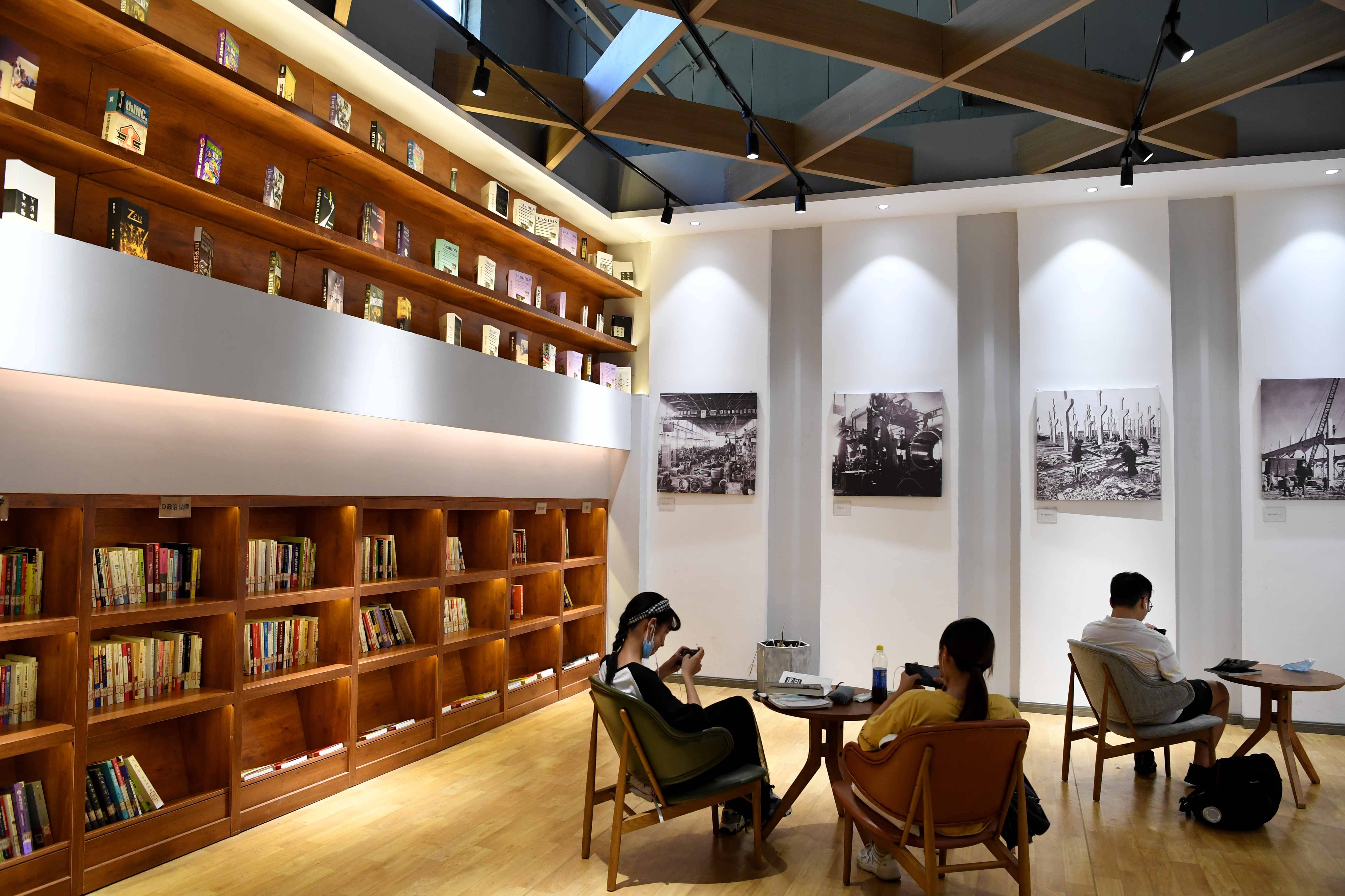 8月4日,在合肥长江180艺术街区,人们在由老厂房打造的拾光书屋里休闲.