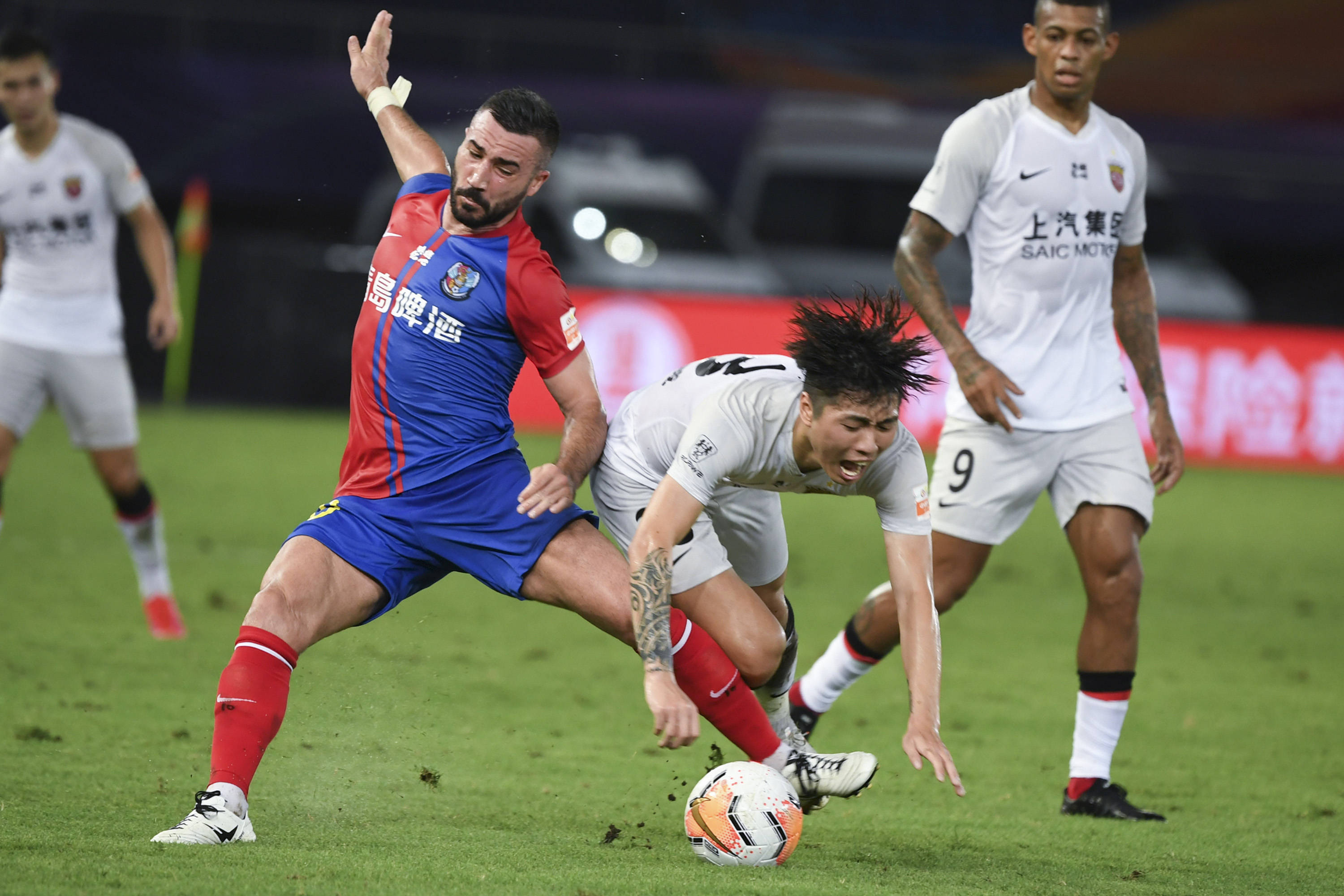 8月6日,青岛黄海青港队球员亚历山德里尼(左)在比赛中争抢.