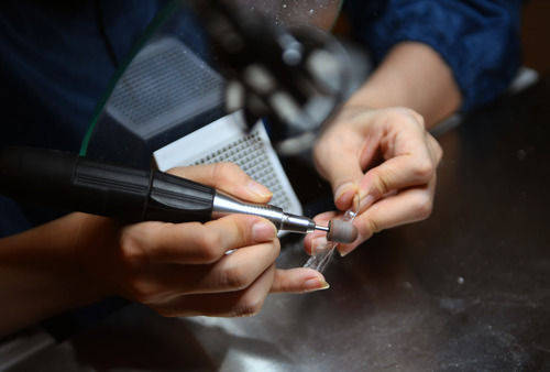 8月13日,一名听障员工在打磨牙齿模具.