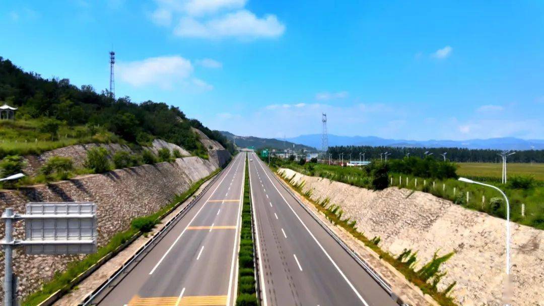 这里是晋济高速,在我身后,工人师傅们正在对匝道口的树木进行修剪和