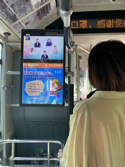 公交车移动电视前,乘客观看公益宣传片和海报