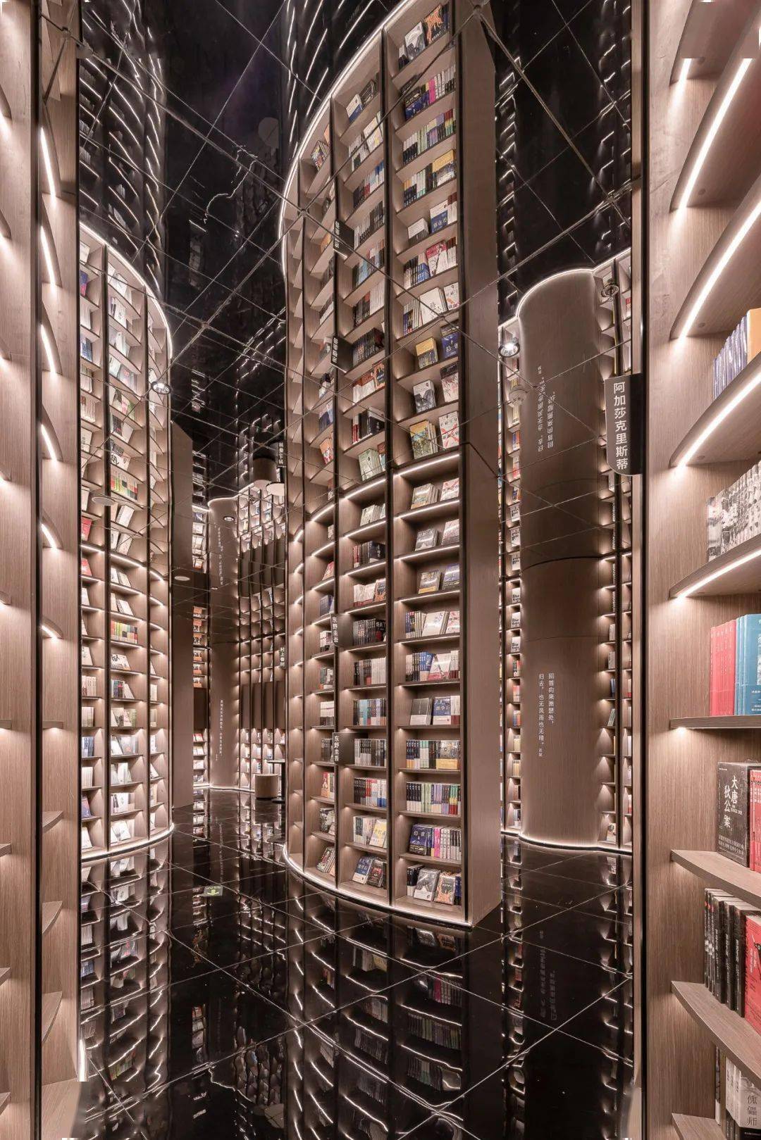 推开钟书阁字幕墙玻璃门,朴质胡桃木色的c形片状书架矗生林立在眼前