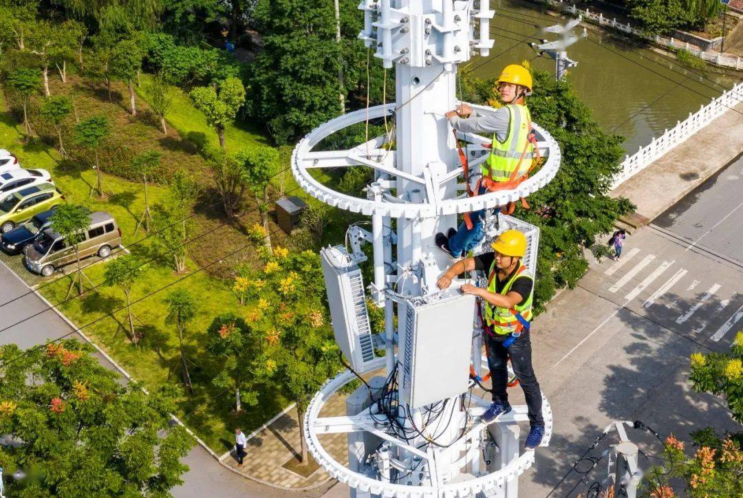 携带各种工具,腰间绑着安全绳,爬上30米高的铁塔顶端安装5g无线主设备