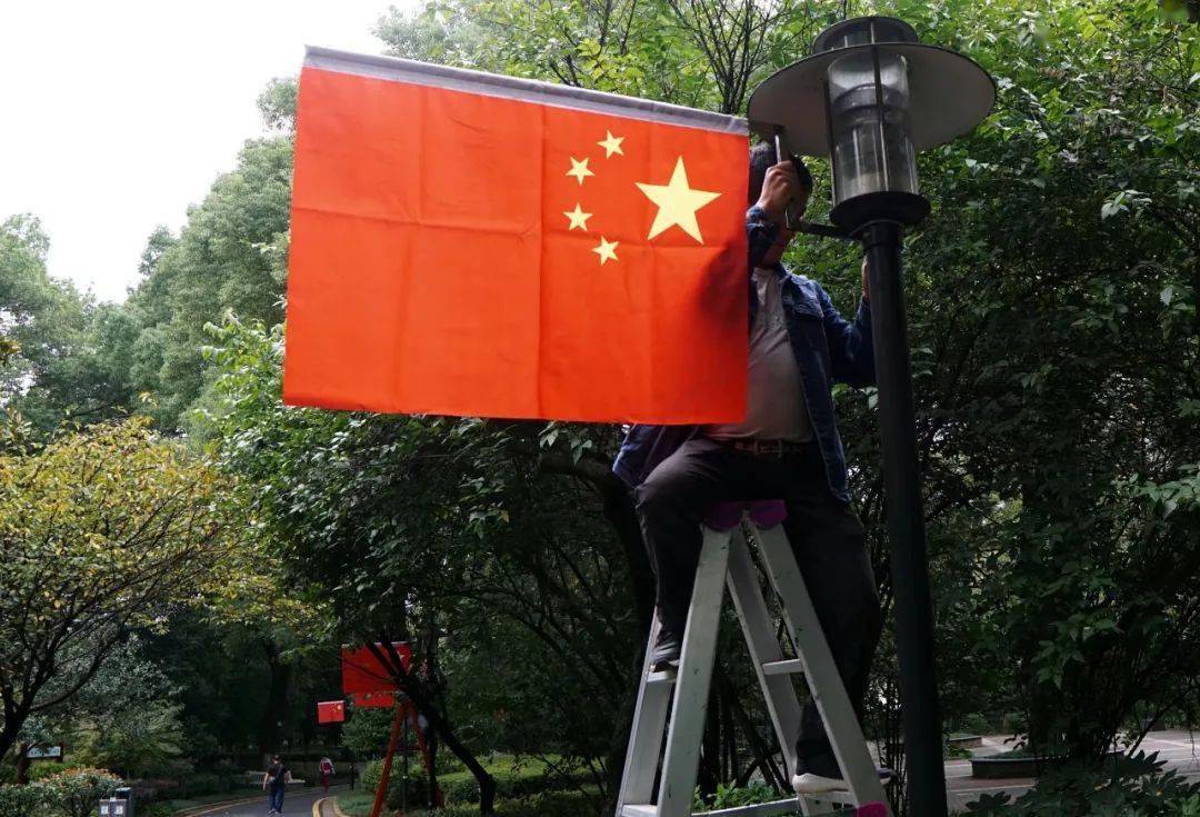 伴随着五星红旗的升起表达心中的喜悦挥舞着手中的国旗人们的脸上挂满