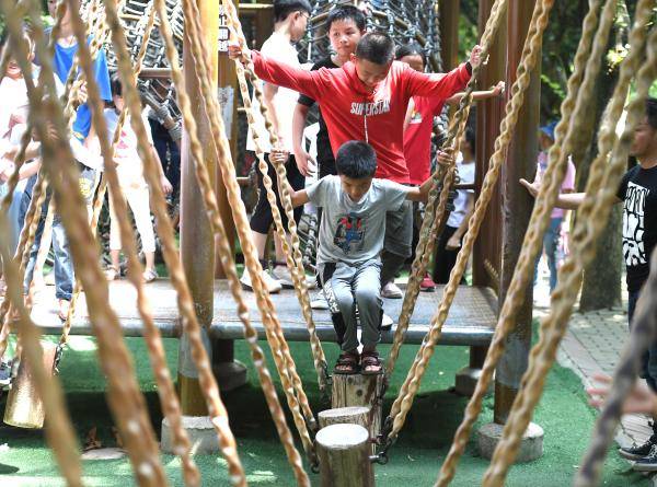 10月4日,孩子们在广西南宁市青秀山风景区陆地拓展竞技乐园玩耍.