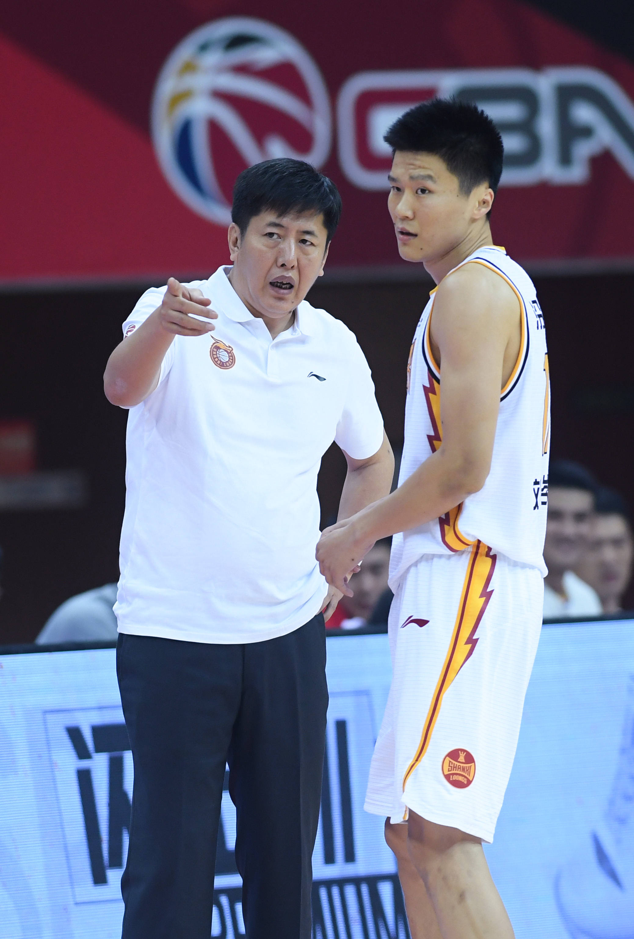 10月27日,山西汾酒股份队主教练丁伟(左)在比赛间隙与球员刘冠岑交流.