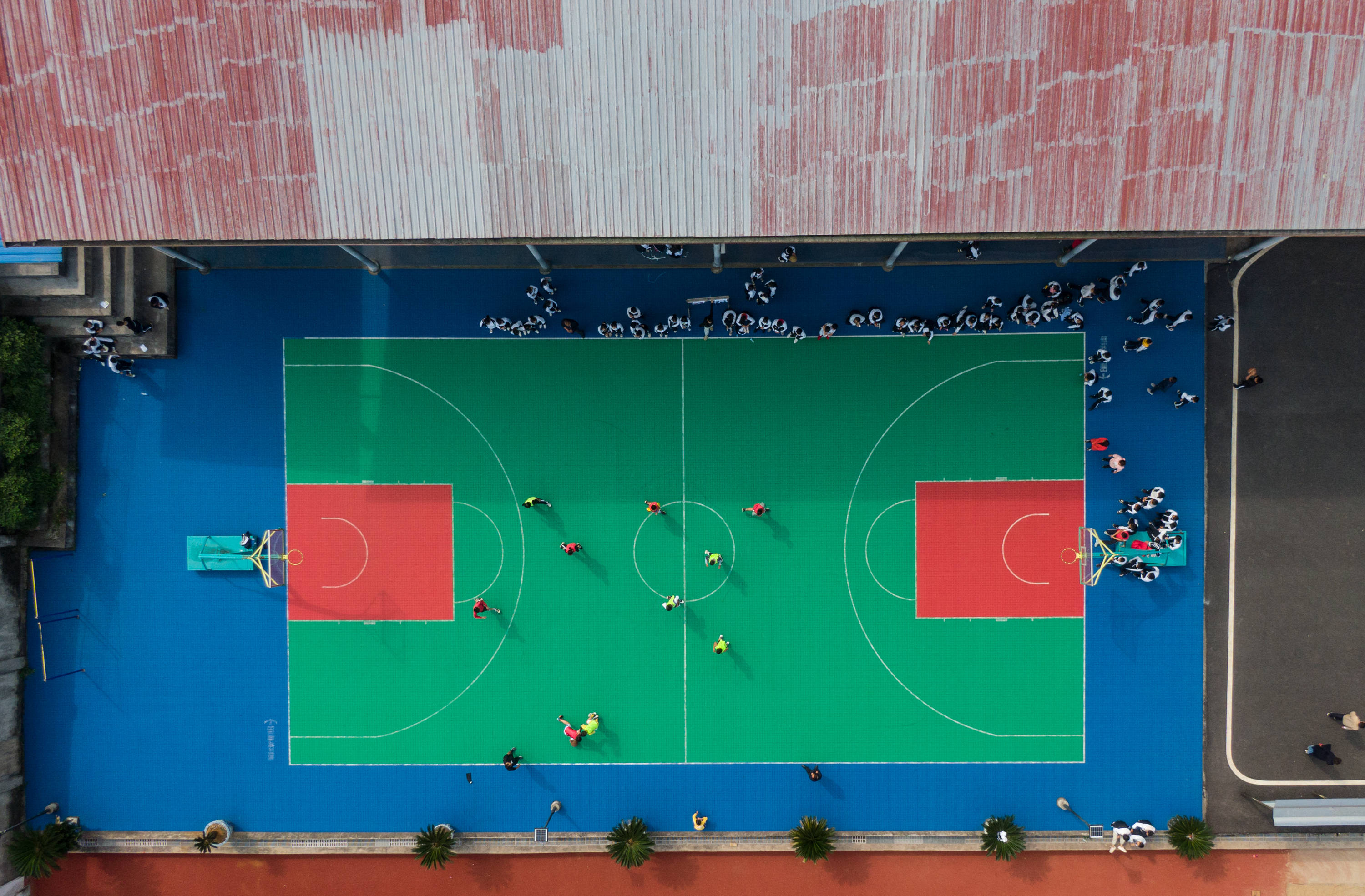 11月3日,曾红(右二)在学校的一场篮球对抗赛中给学生们加油.