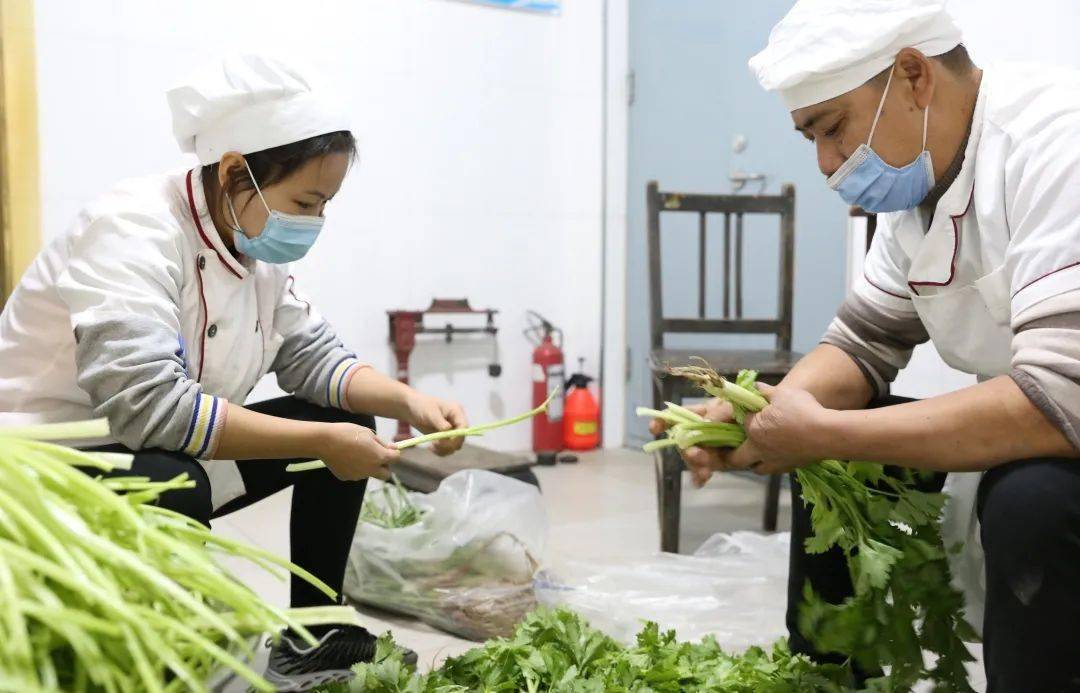 "整齐摆放的消毒柜,一尘不染的操作台工作人员正在摘菜走进区直机关